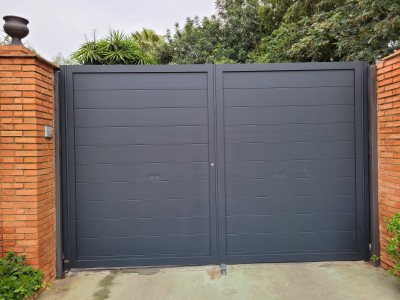 Puerta abatible de 2 hojas automática de aluminio soldado en Palos de la Frontera (Huelva)